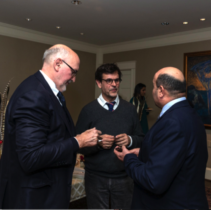 (L to R) Movie director Jacques Charmelot and his photographer chat with the Iraqi defense attaché.